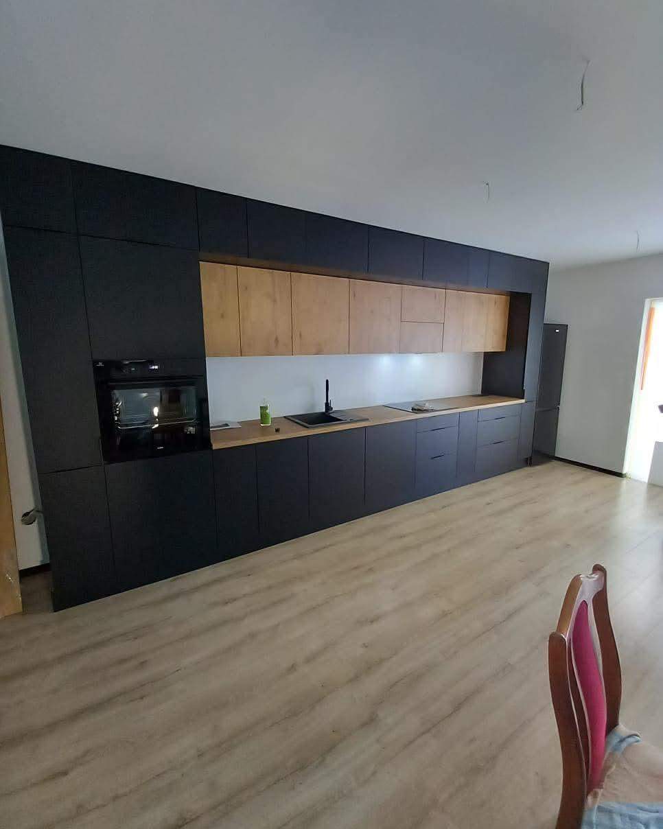 czarna ściana kuchenna z elementami drewnopodobnymi 