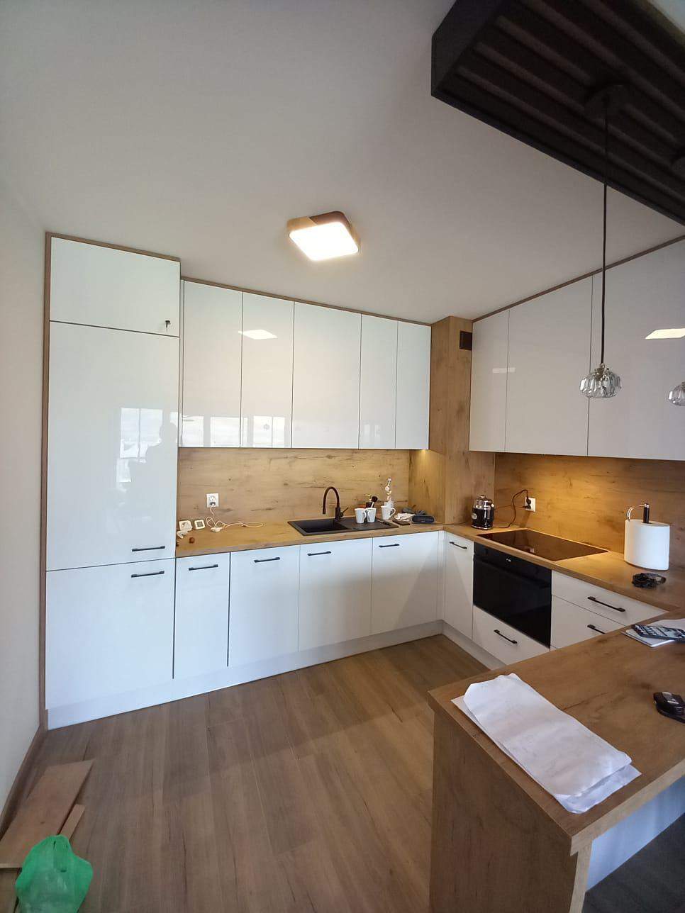 biała kuchnia wychodzącą na salon na wymiar z półwyspą