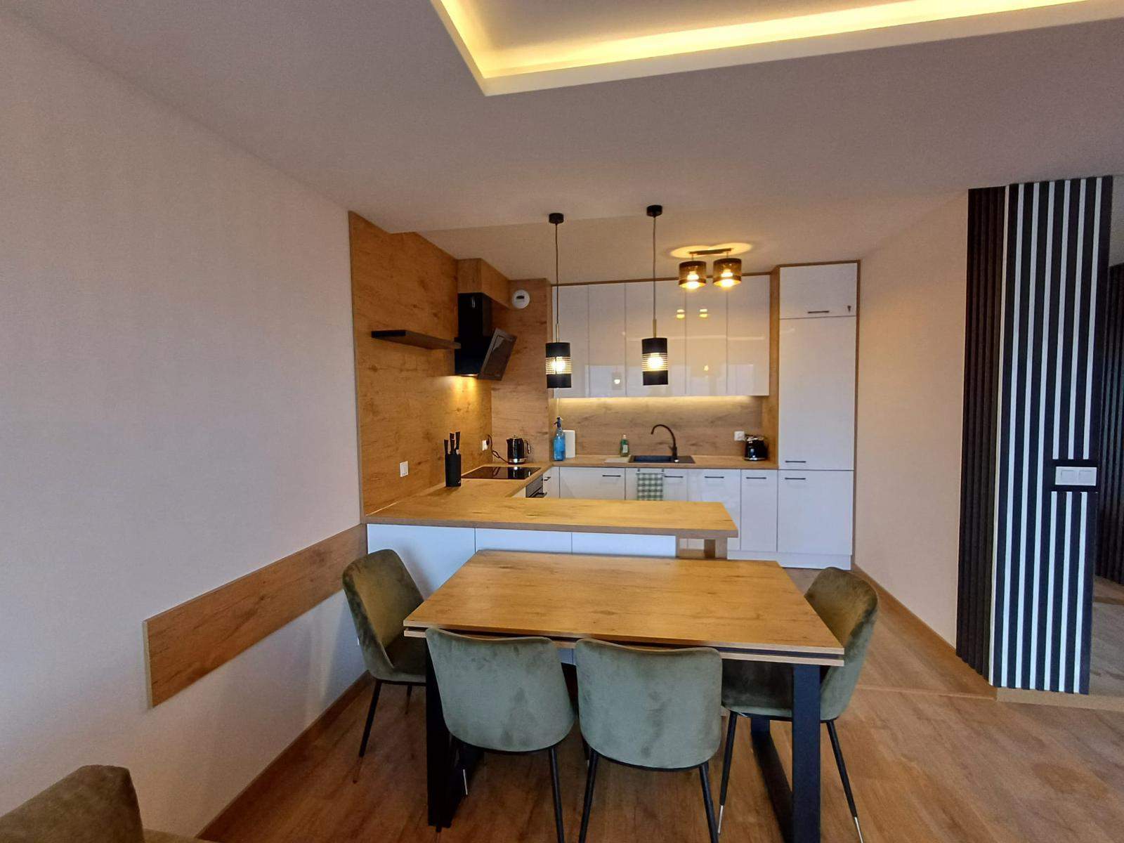 narożnikowa biała kuchnia wychodząca na salon