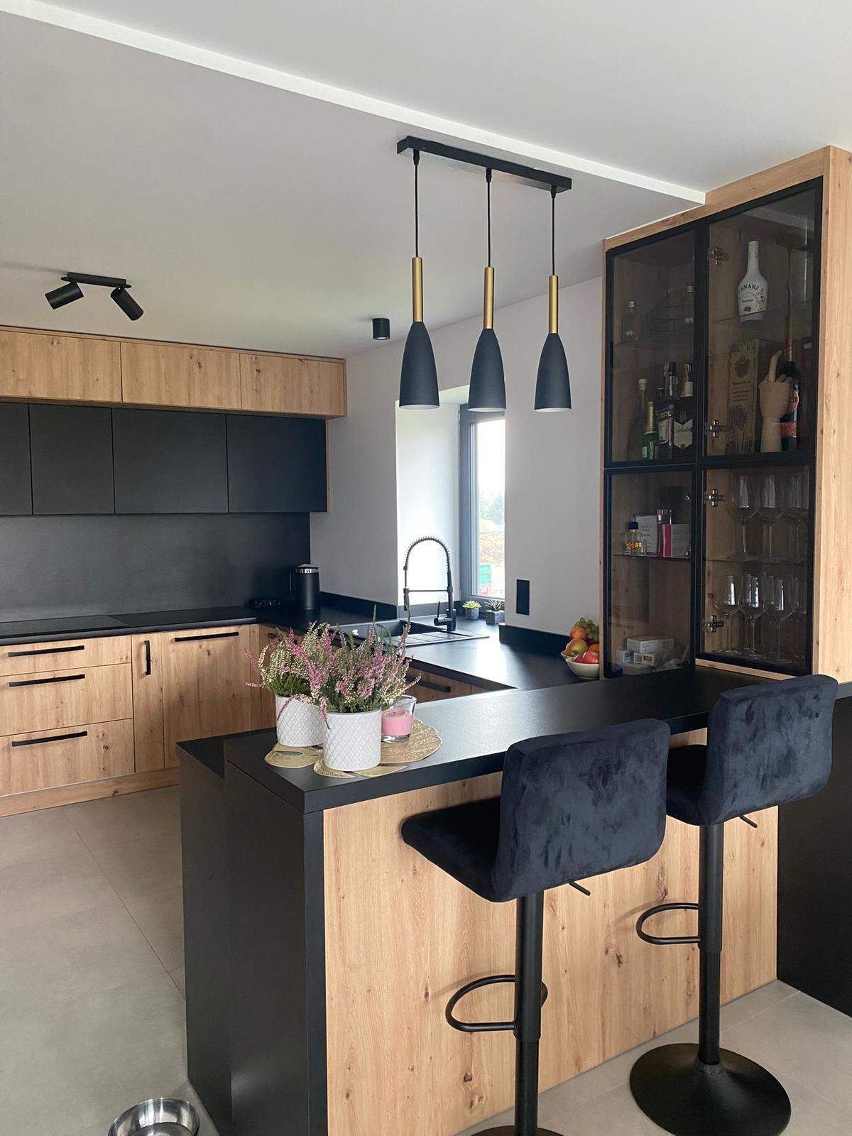 Loftowa kuchnia z czernią i drewnem oraz witryną  i barem śniadaniowym