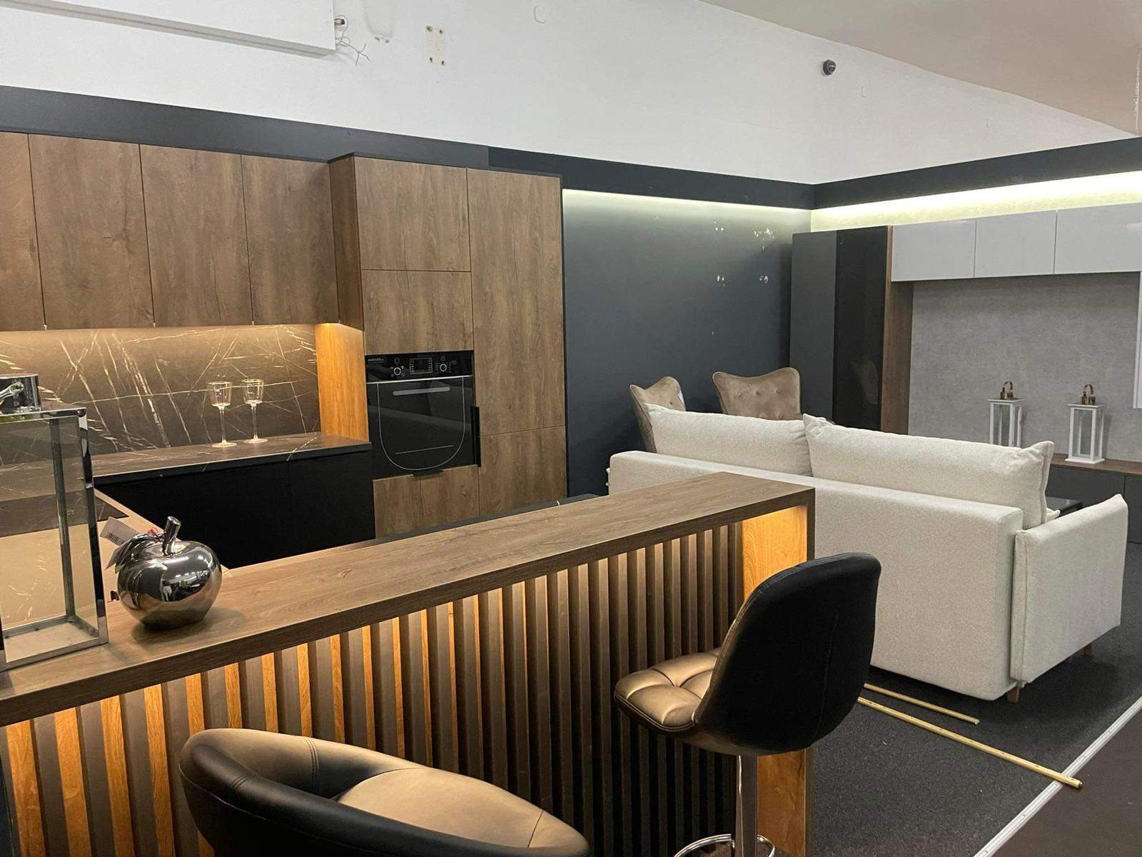 meble kuchenne z ladą z lamelami drewnianymi i czarnym blatem 