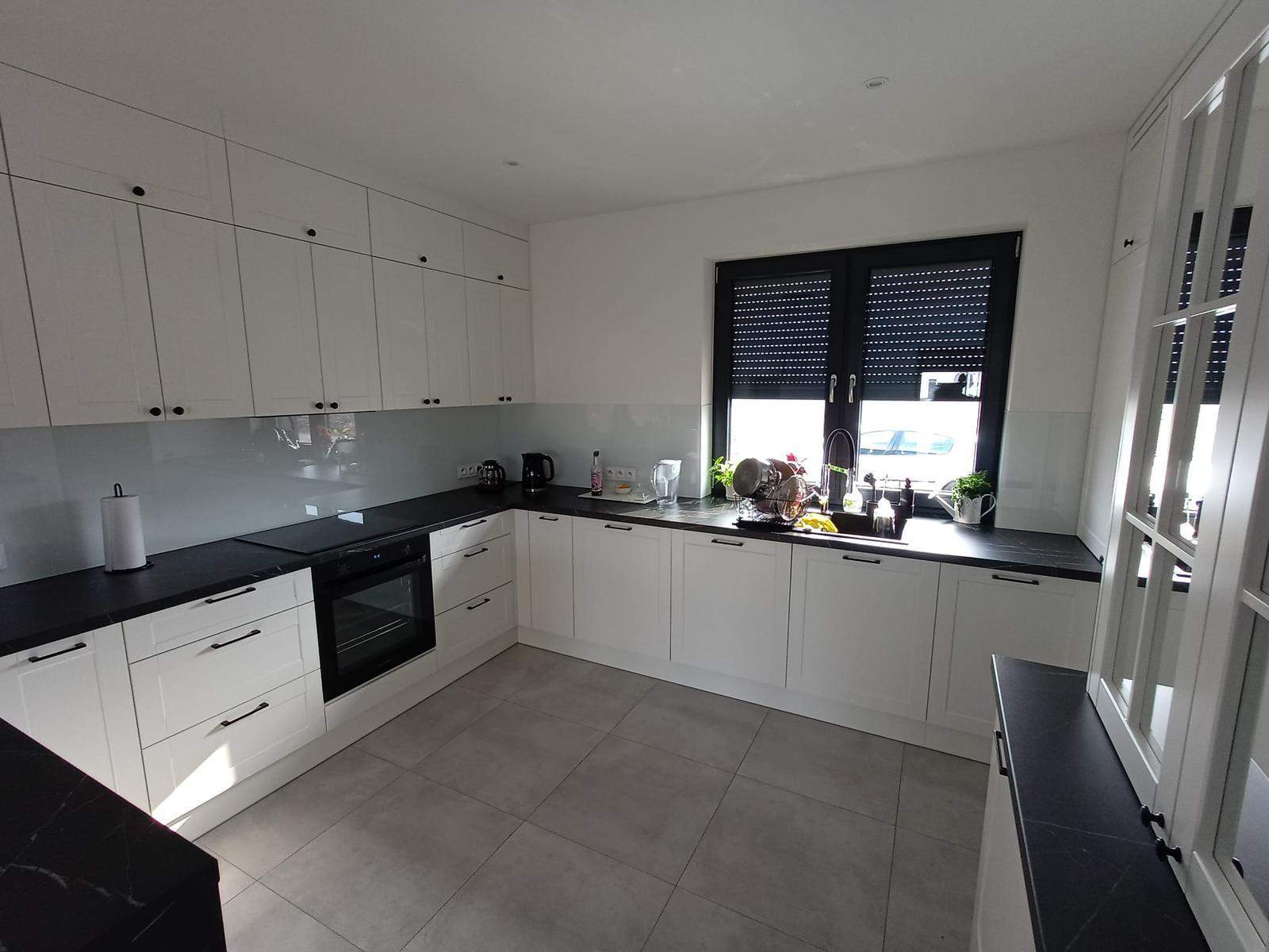 duża biała kuchnia z czarnymi blatami wykonana na wymiar 