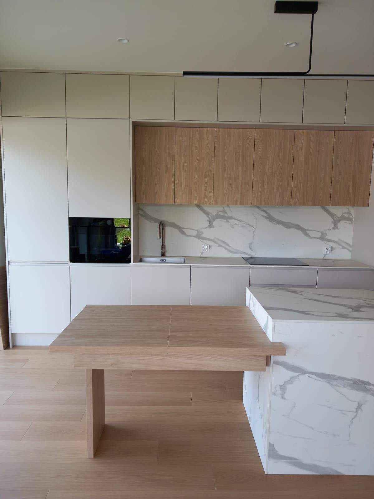 Biała kuchnia lakierowana z frezowanym uchwytem oraz drewnianym wykończeniem  na wymiar 